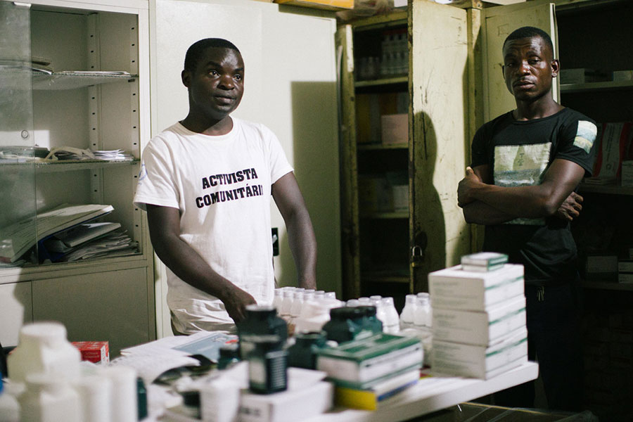 two men standing in a crowded storage room