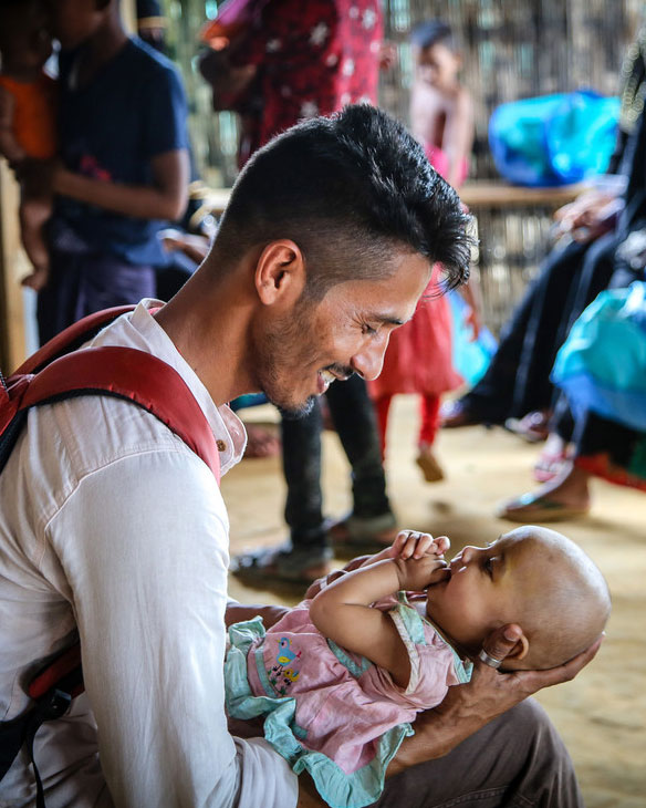 father smiling down on the baby he holds
