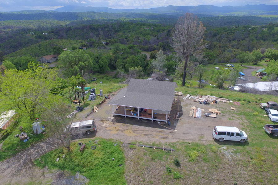 an aerial view of a home being built on top of a hill