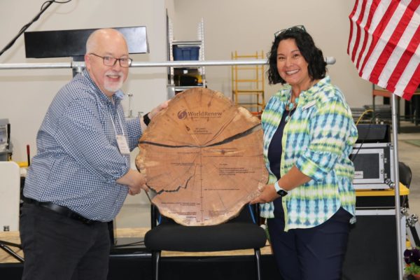 World Renew Canada presents Bremer-Bennett with a wooden plaque.