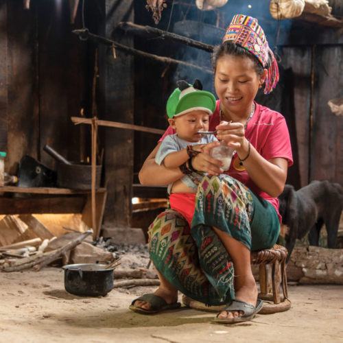 A woman feeding her baby.