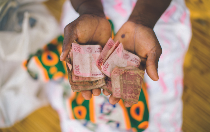 A woman holds currency.