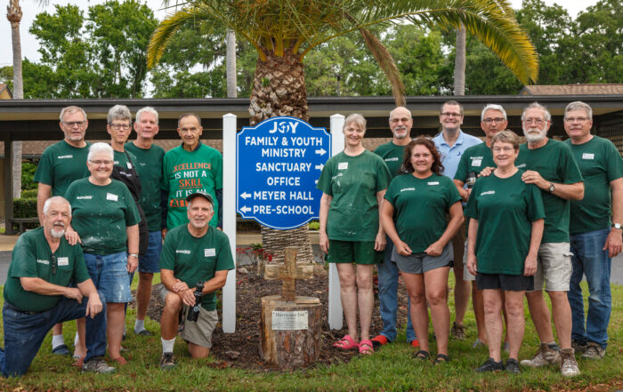 A group of DRS volunteers stand with a sign