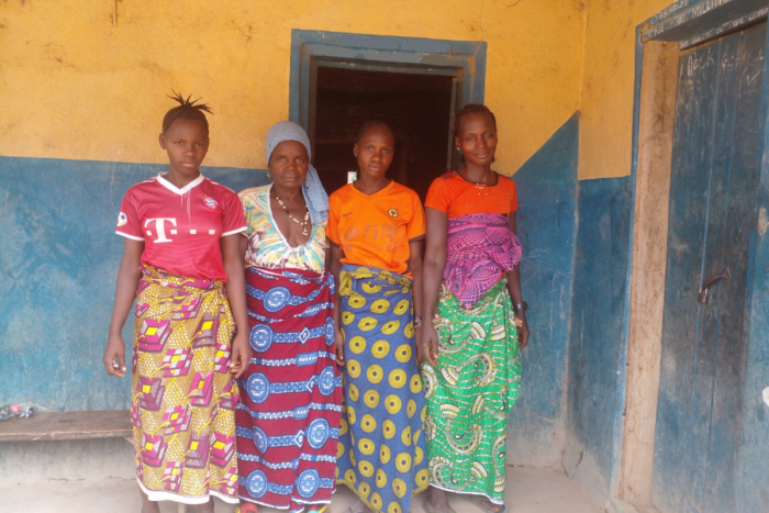 Women stand in front of a door in Sierra Leone