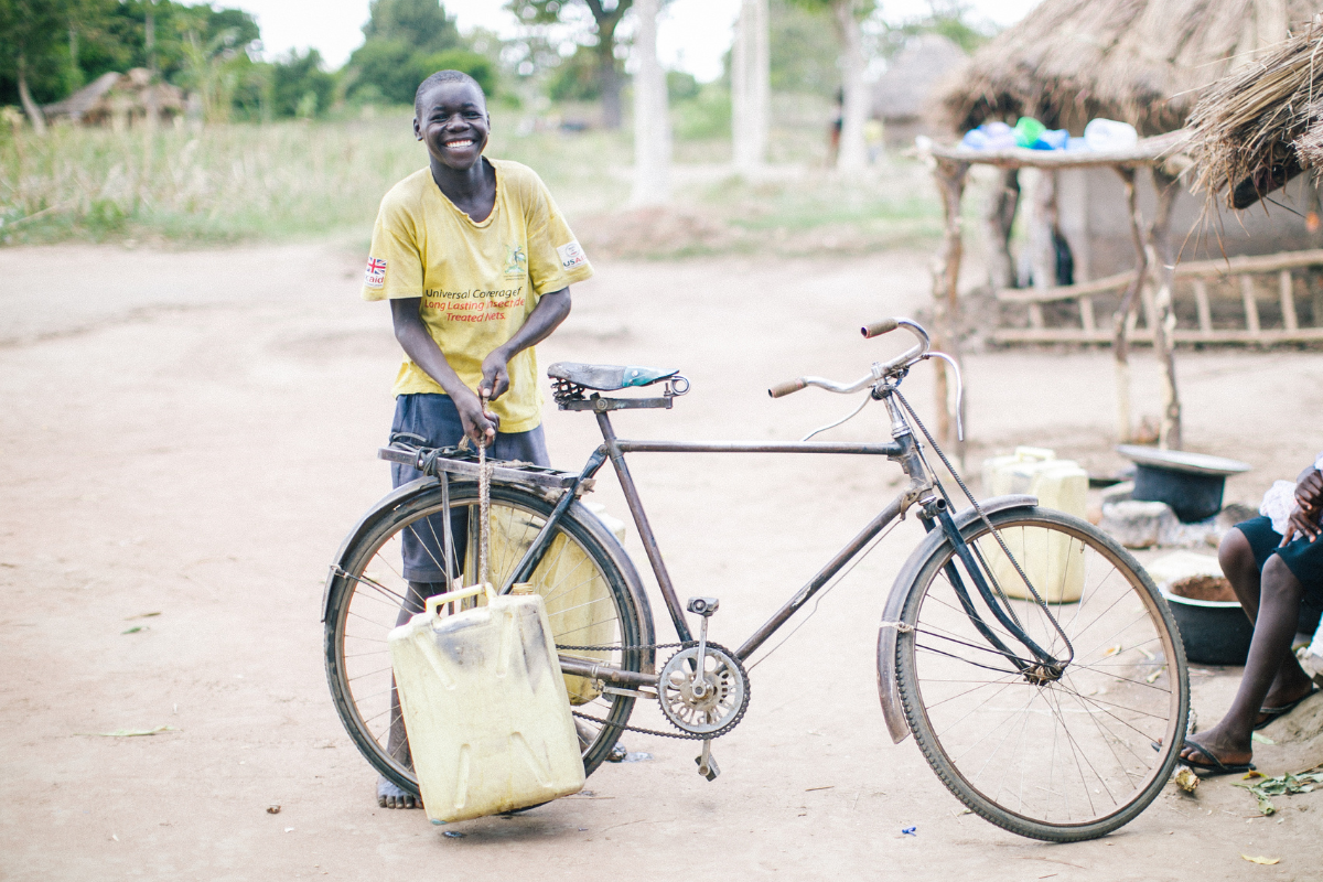 A child with a bike and a water jug