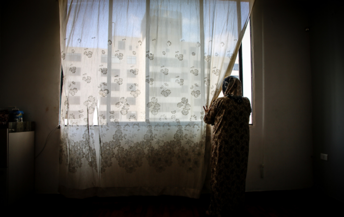 A woman stands at a window