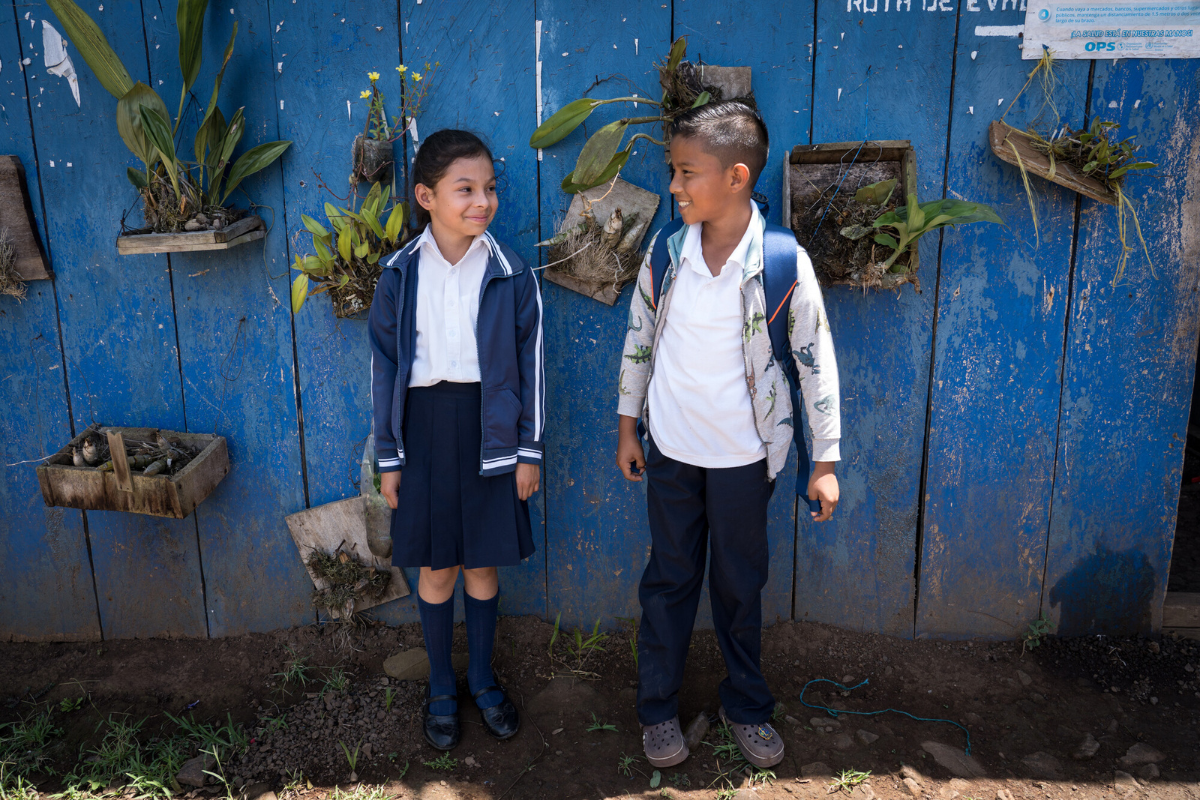 School children stand in front of a wall