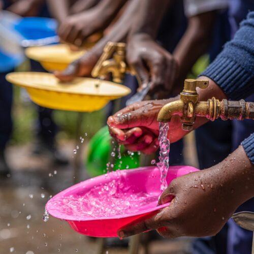 Children fill bowls with water
