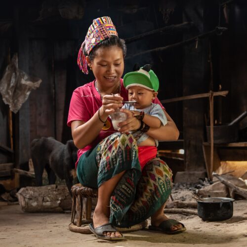mother spoon-feeding infant