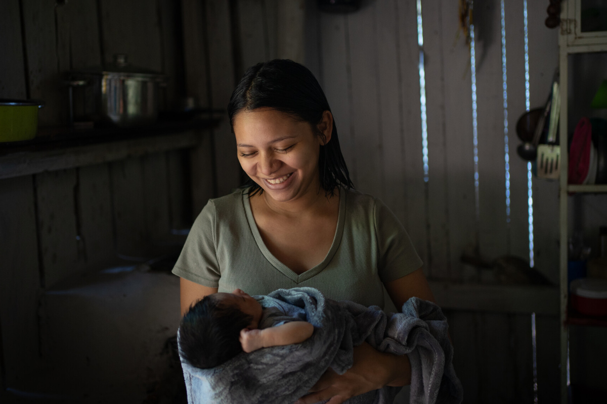 Mom smiles while holding her baby